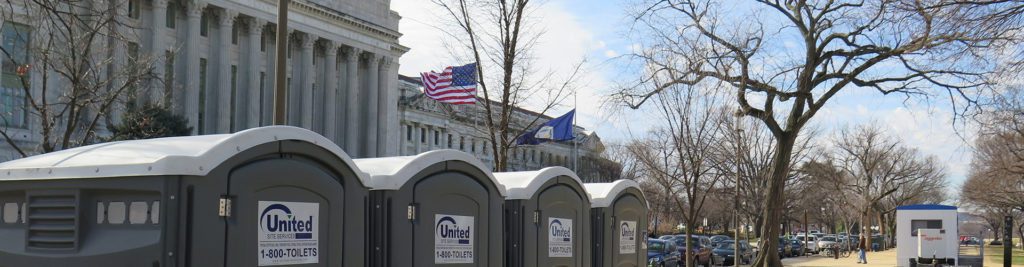 four porta potties in front of a government building