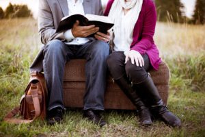 Two people sitting down reading