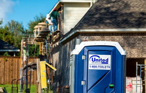 a porta potty on site of a home being worked on