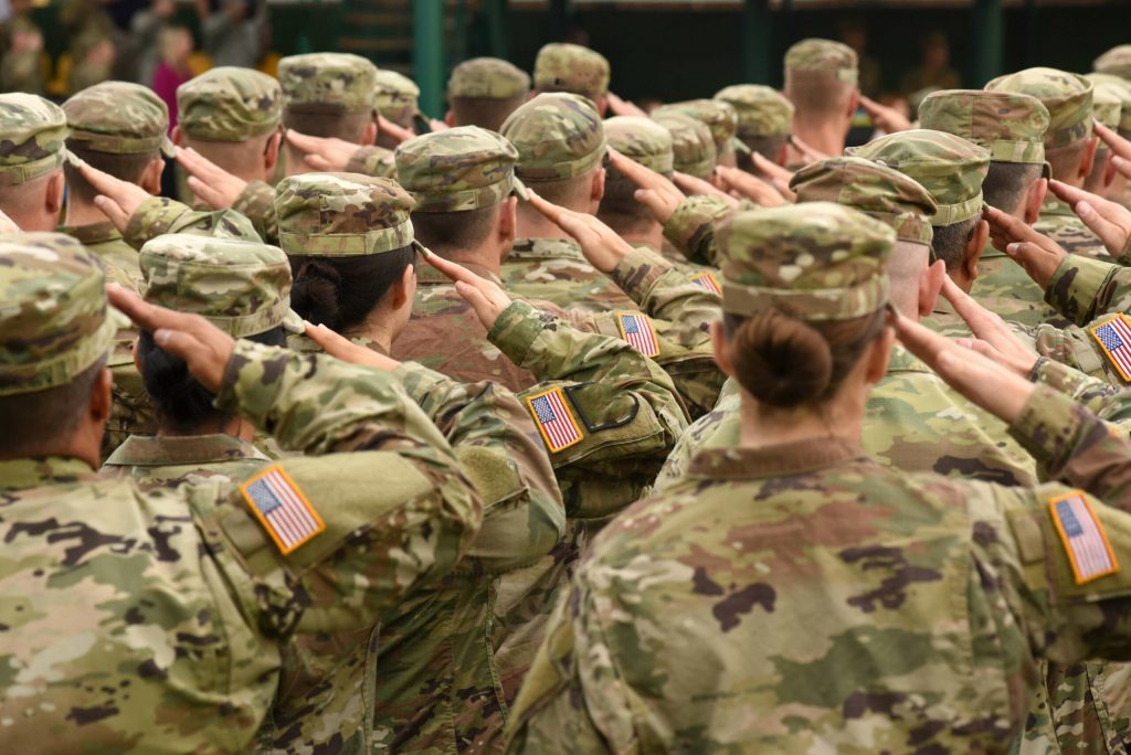 a group of men and women in the armed forces saluting