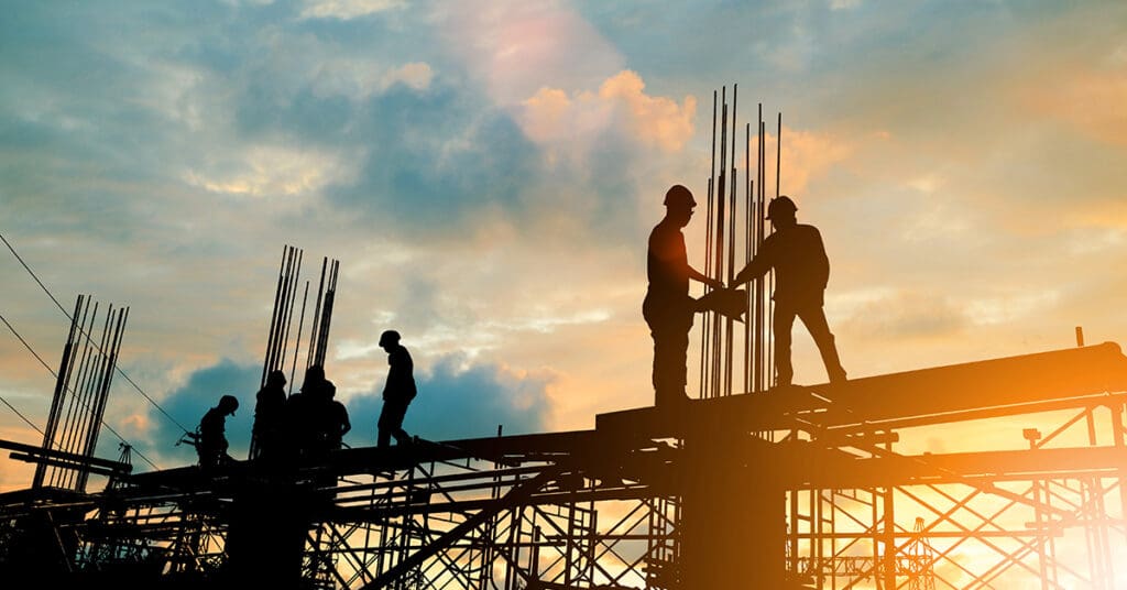 Silhouette of construction team working on top of a site